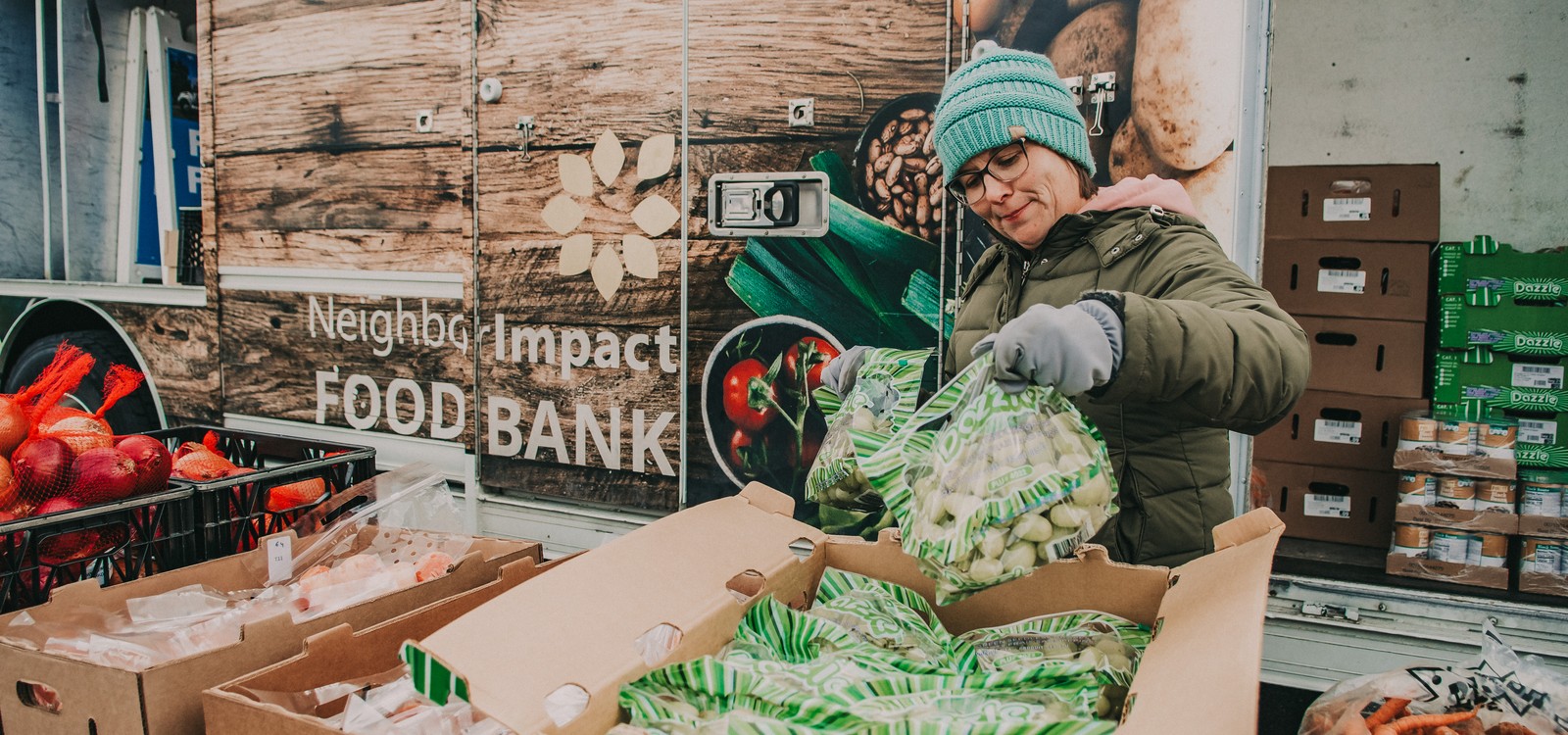 A person packs produce beside the NeighborImpact Food Bank mobile pantry.