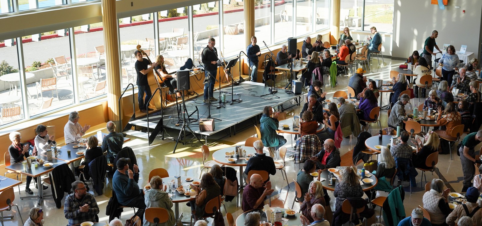 Community members gather at tables with live music at Empty Bowls.